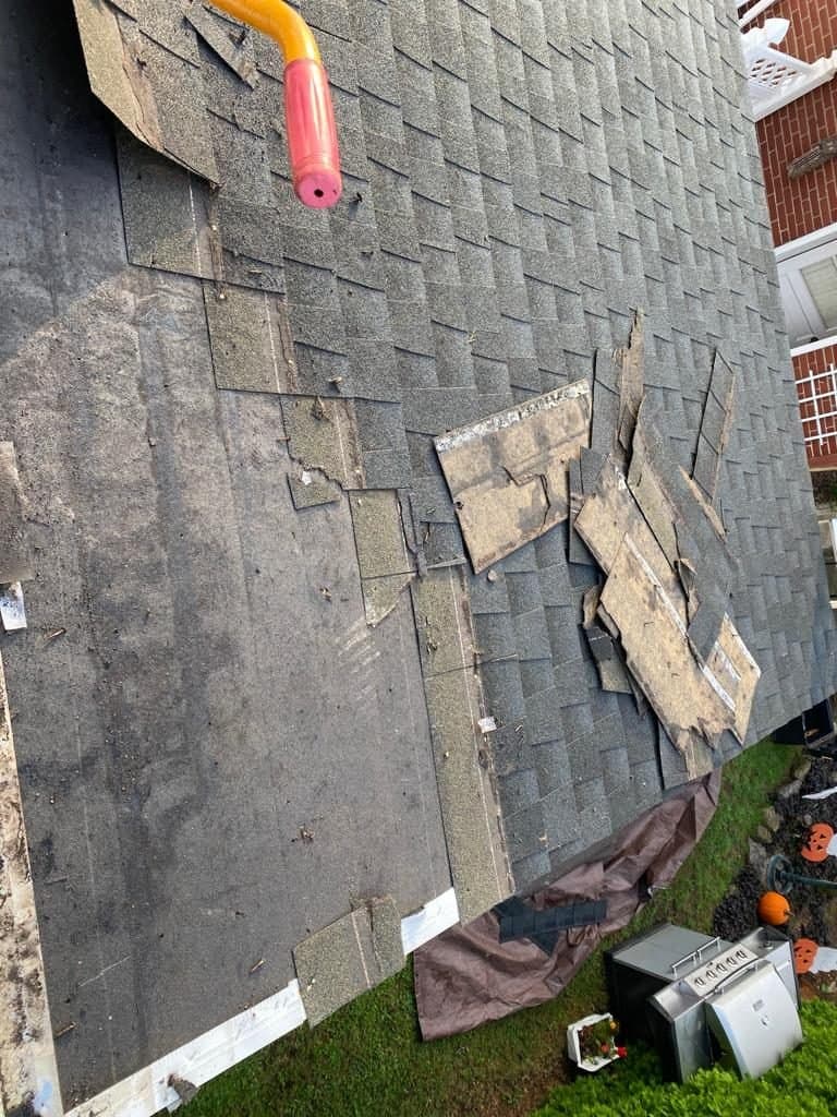 Wind-damaged shingles before a roof repair in Berks County, PA